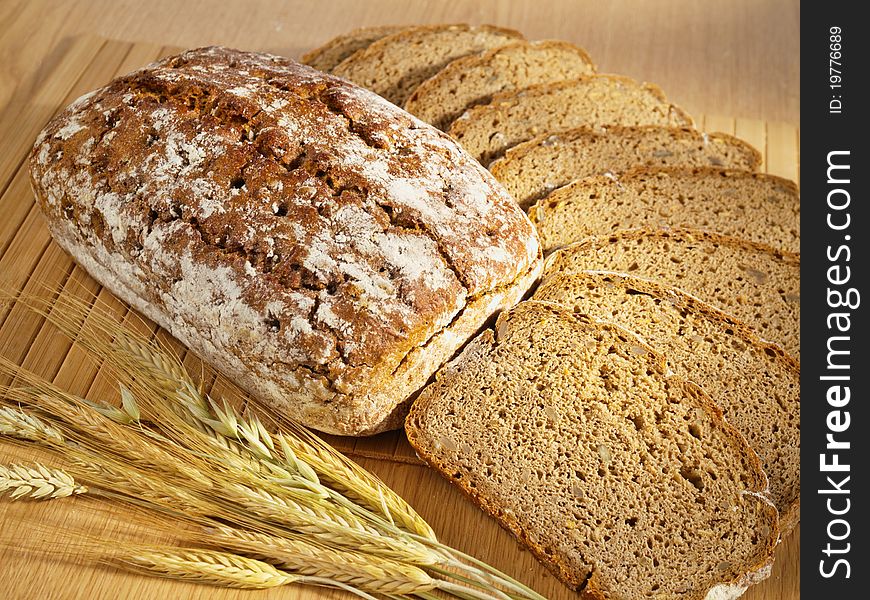 Freshly baked bread and wheat on table