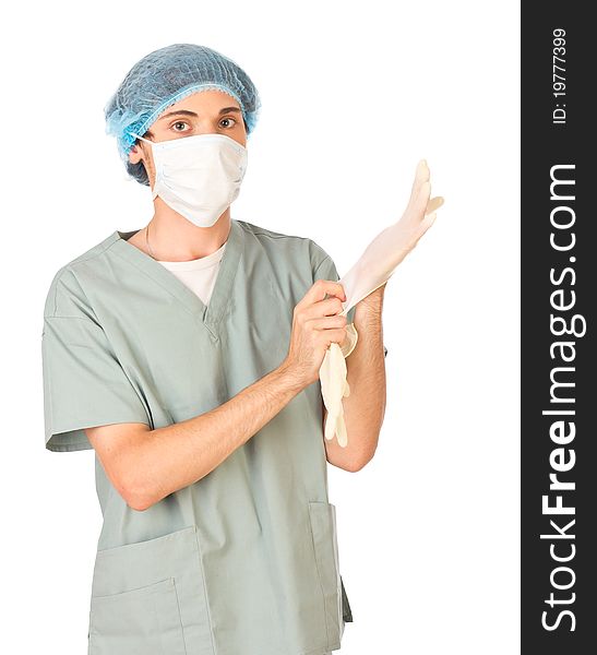 Young medical worker in mask standing and putting on gloves. Young medical worker in mask standing and putting on gloves