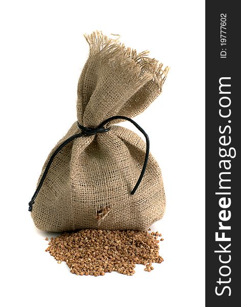 Scattered bag with buckwheat on white background