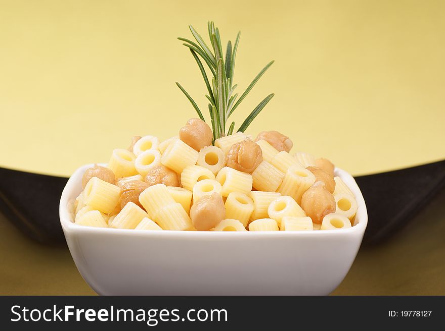 Small thimbles (ditalini) with chickpea and rosemary served in a white plate. Small thimbles (ditalini) with chickpea and rosemary served in a white plate