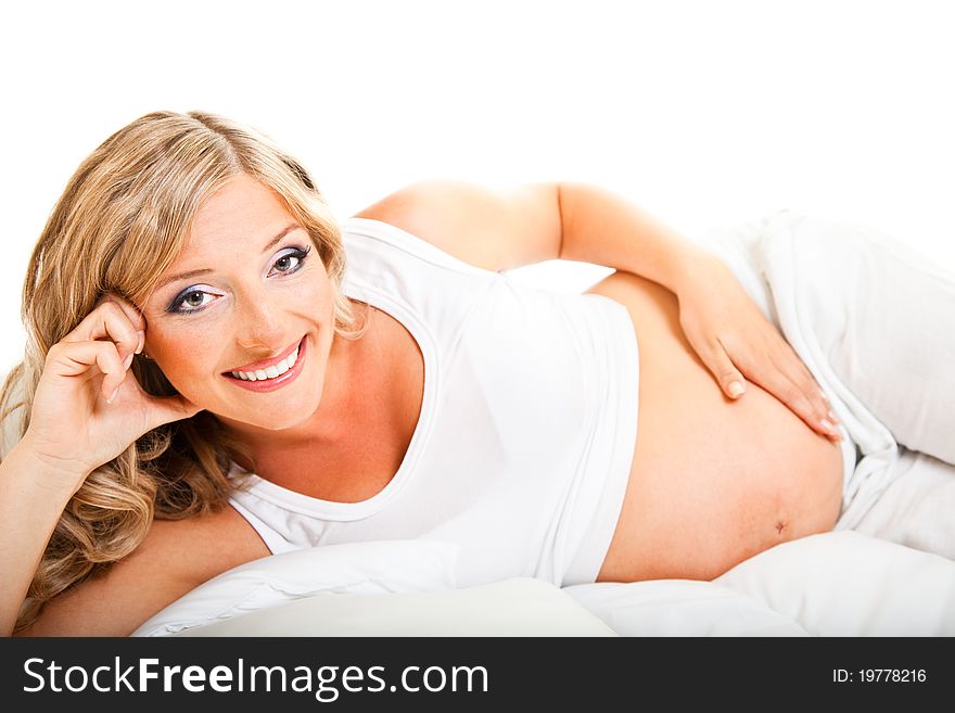 Pregnant woman in bed isolated on white