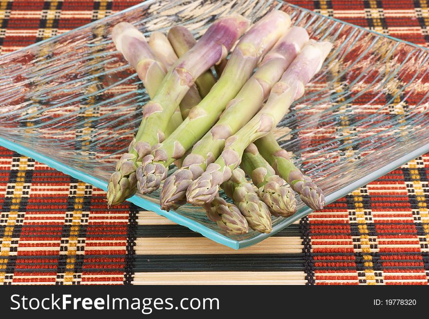 Raw asparagus on a glass plate