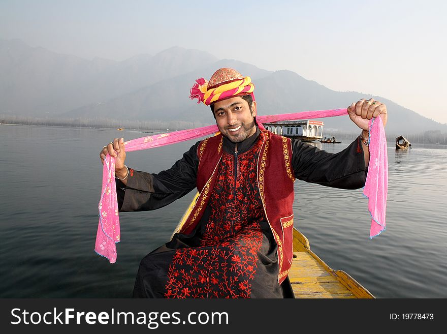 Pathani boy (North Indian) in tradition burqa dress sitting on a shikara boat and dancing to a folk song with a pink shawl in hand. Pathani boy (North Indian) in tradition burqa dress sitting on a shikara boat and dancing to a folk song with a pink shawl in hand