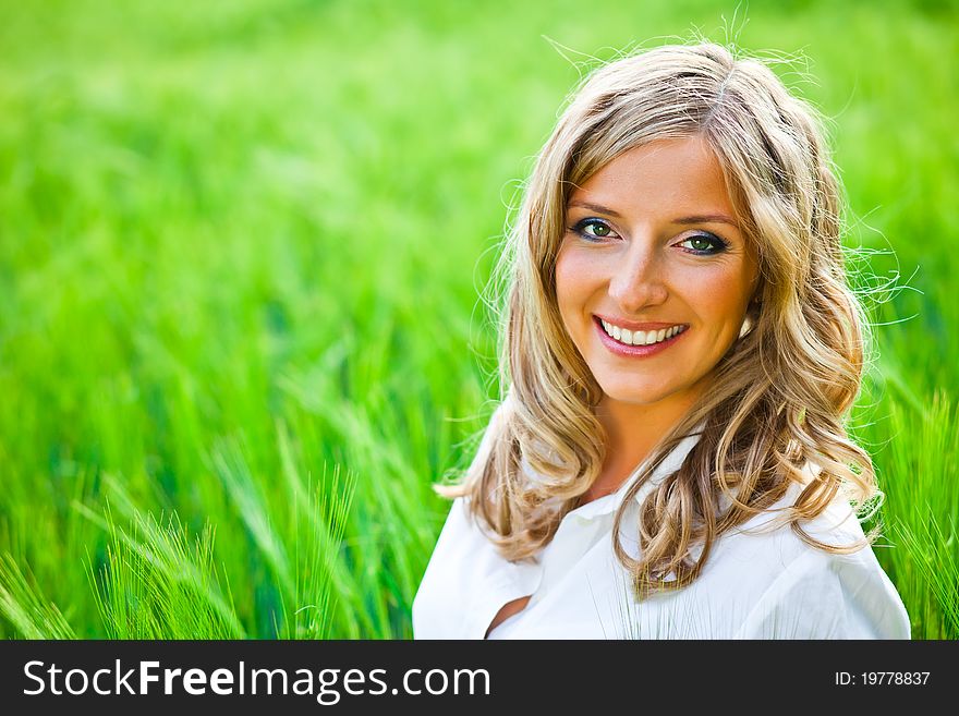Blond woman portrait outdoor on green field