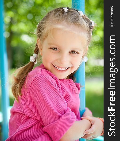Cute little girl smiling in a park close-up