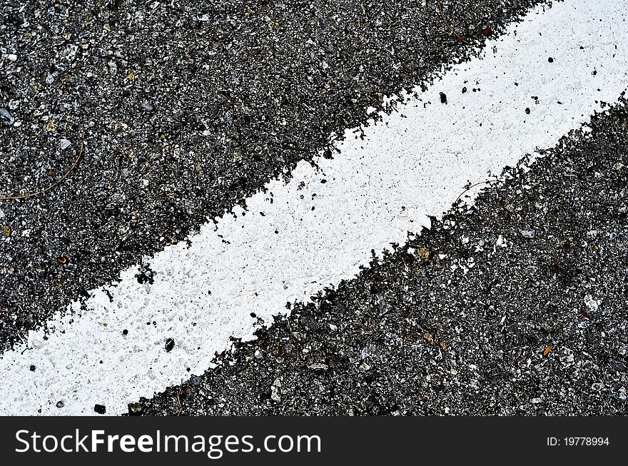 Closeup of a tar or asphalt pavement texture with a white line painted. Closeup of a tar or asphalt pavement texture with a white line painted