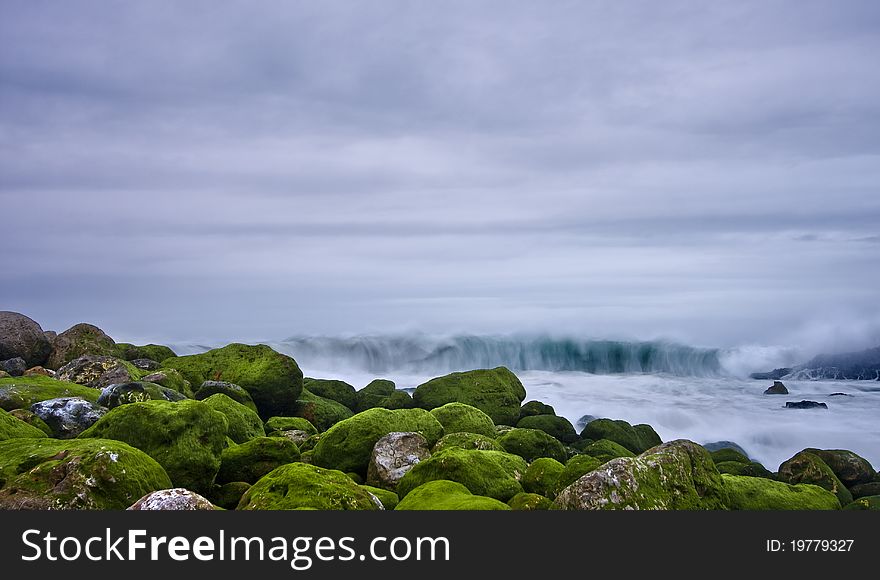 Green stones in beach and great wave. Green stones in beach and great wave
