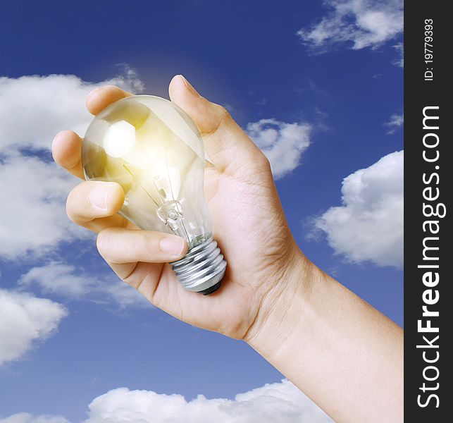 Light bulb in hand the sky background