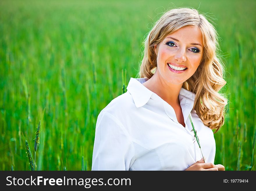 Blond woman portrait outdoor on green field