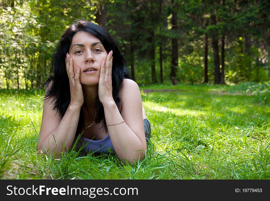 Beautiful middle-aged woman lying on grass