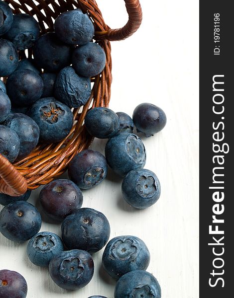Little basket with fresh blueberries on white wooden table. Little basket with fresh blueberries on white wooden table