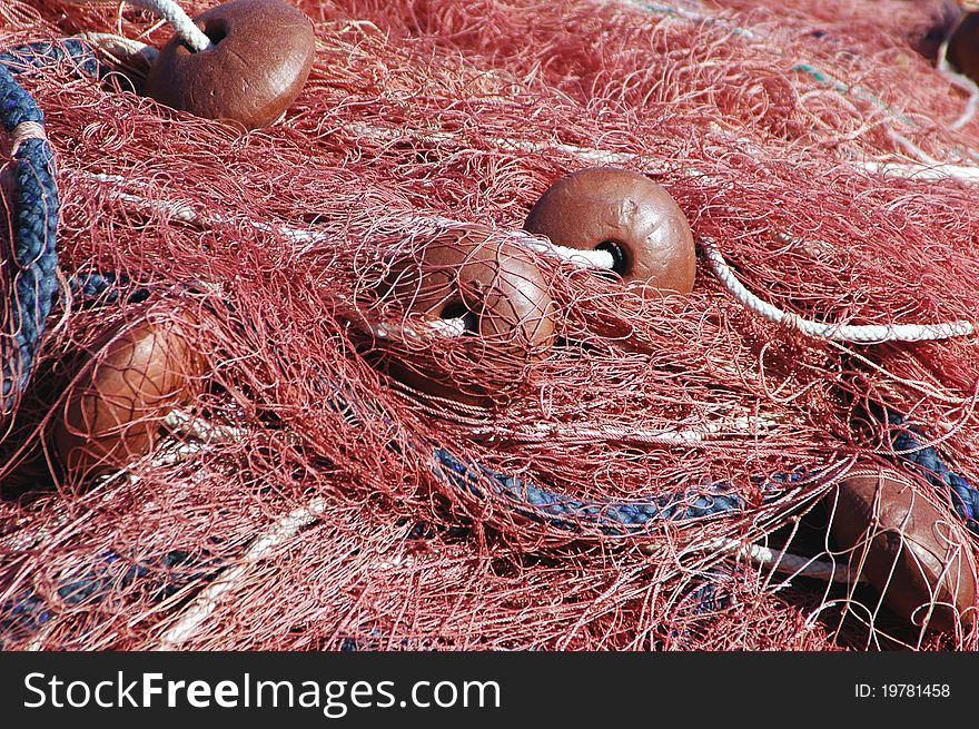 Red fishing net, rope and buoys closeup. Red fishing net, rope and buoys closeup