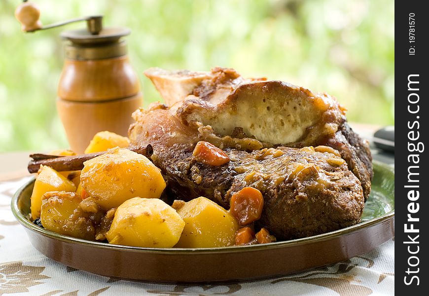 Roasted beef leg with potato and carrot. Selective focus. Roasted beef leg with potato and carrot. Selective focus