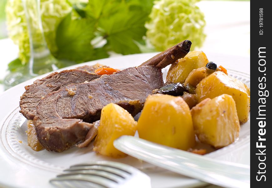 Roasted beef leg with potato and carrot. Selective focus. Roasted beef leg with potato and carrot. Selective focus