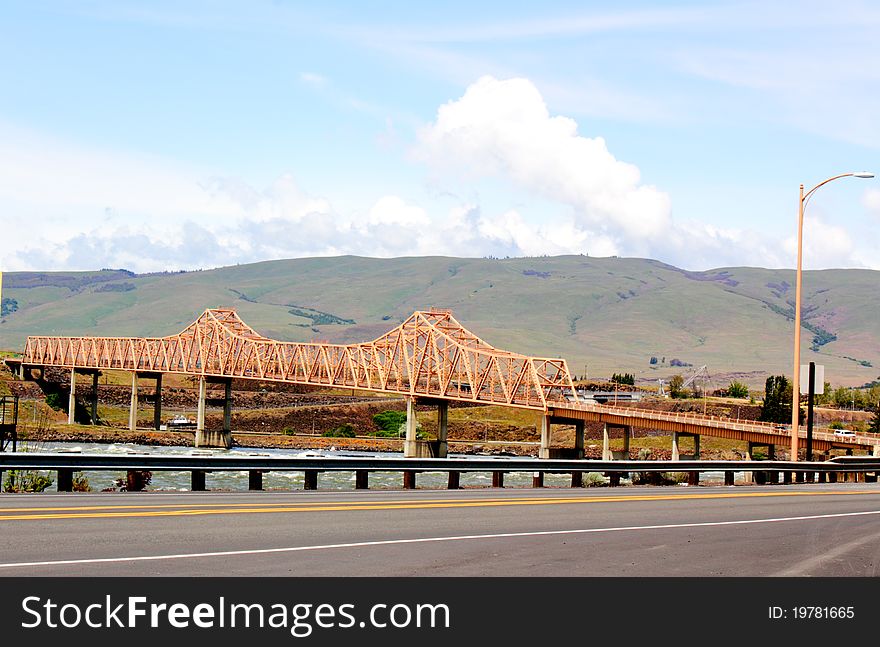 The Dalles Bridge over the Columbia River in the Columbia River Gorge with the rolling hills of eastern Washington in the background.