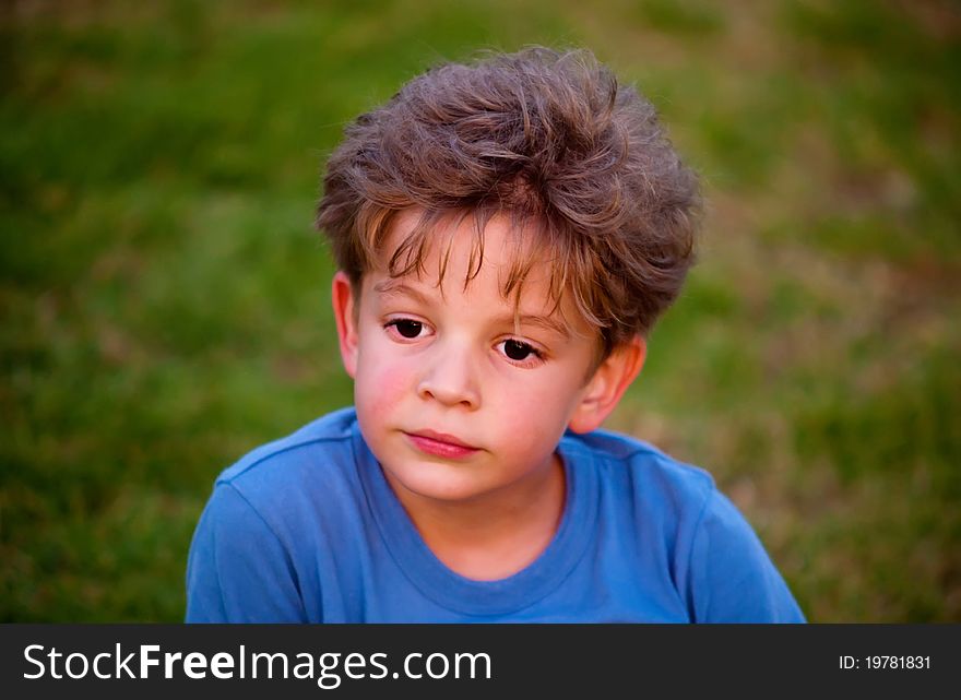 Portrait of happy joyful beautiful little boy against the background of grass . Portrait of happy joyful beautiful little boy against the background of grass .