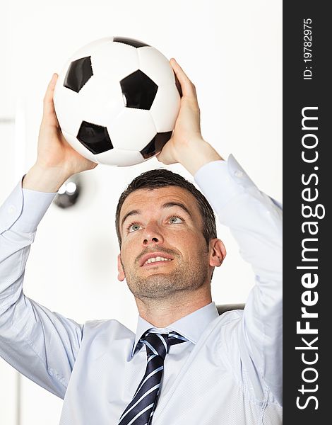 Young businessman in office with ball in the hands. Young businessman in office with ball in the hands