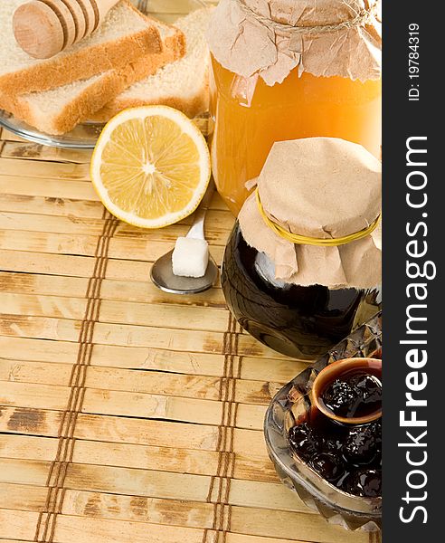 Coffee, honey and bread on table