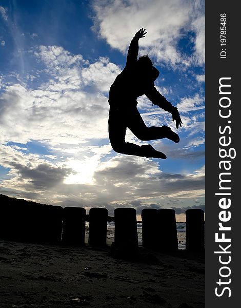 Silhouette of girl jumps in sky