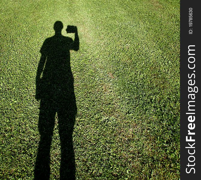 Shadow of photographer standing on grass. Shadow of photographer standing on grass