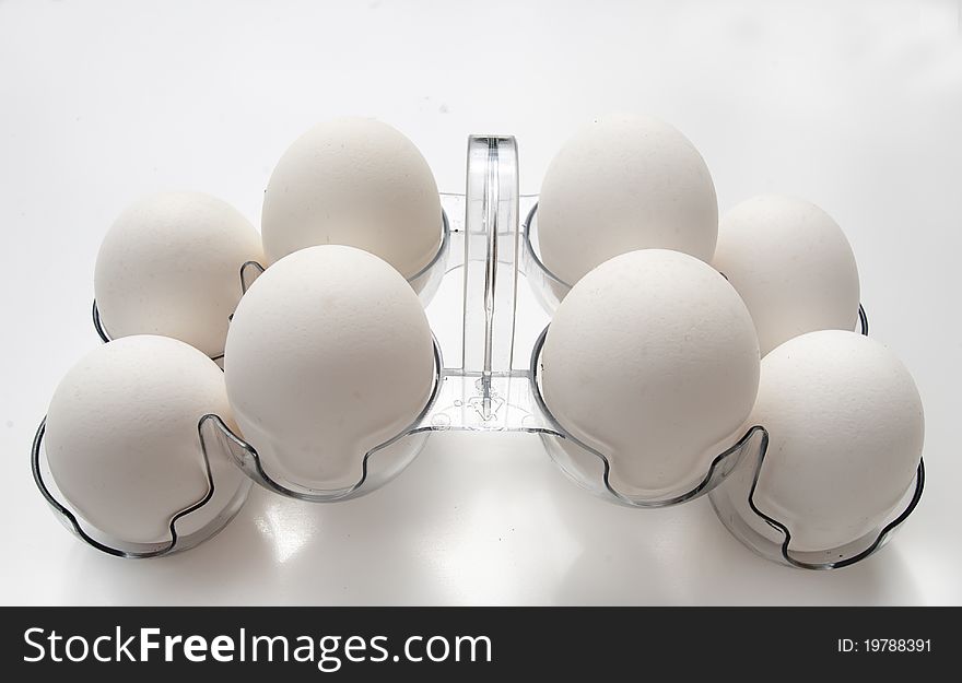 White eggs in the plastic container on white background