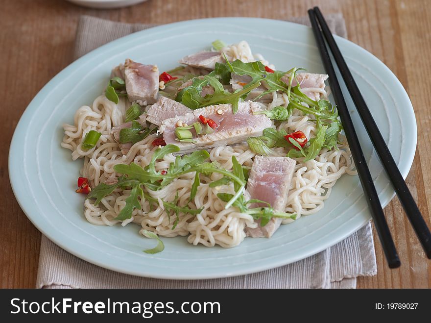 Tuna steak with wasabi noodles and rocket on a plate. Tuna steak with wasabi noodles and rocket on a plate