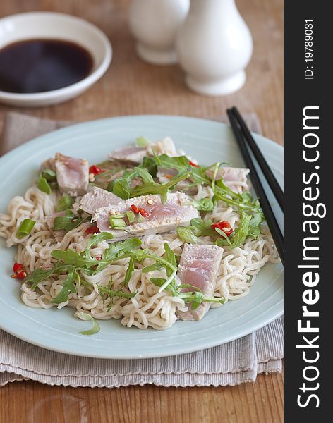 Tuna steak with wasabi noodles and rocket on a plate. Tuna steak with wasabi noodles and rocket on a plate