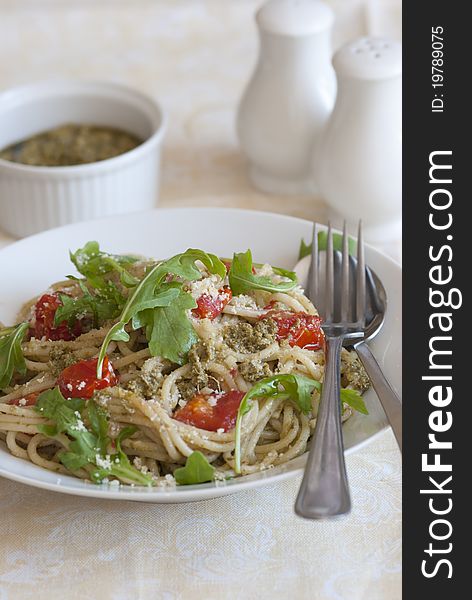 Spaghetti with pesto, cherry tomatoes and rocket in a bowl