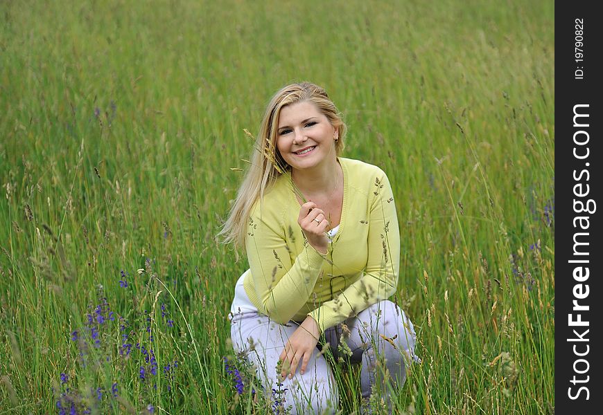 Pretty healthy summer woman outdoors on green field in Alps enjoying freedom. Switzerland