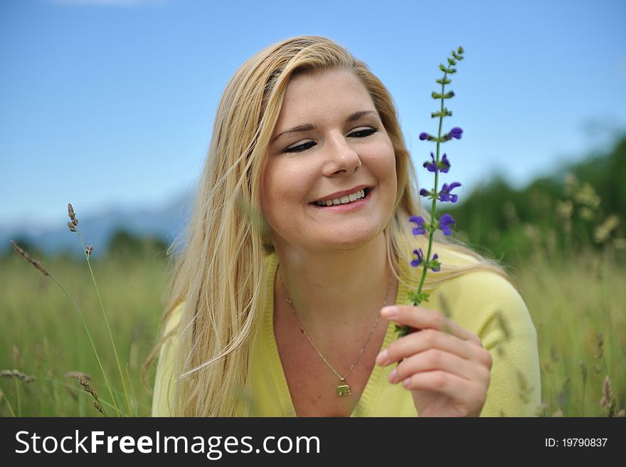 Pretty summer woman outdoors on green field