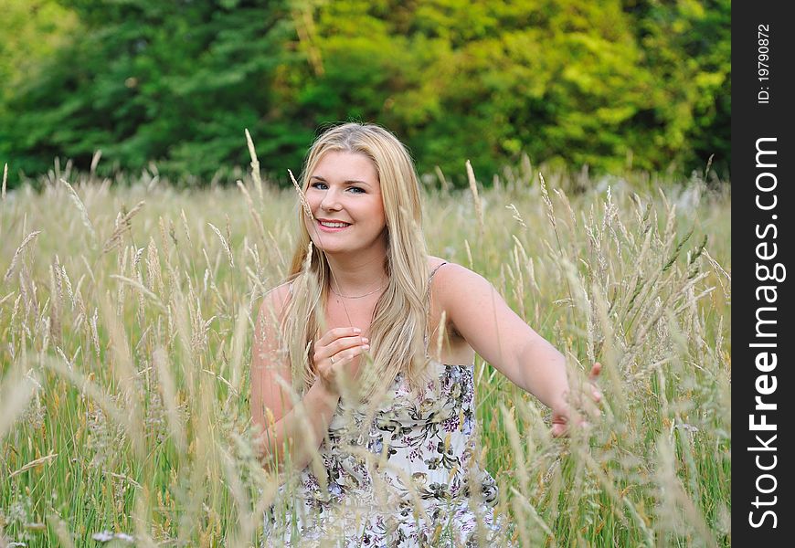 Pretty summer woman on yellow wheat field in countryside