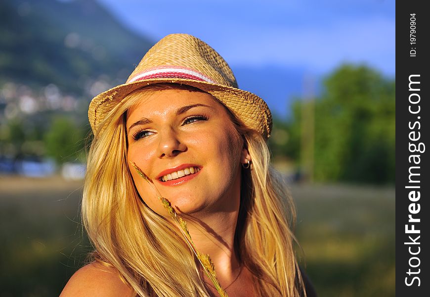 Summer female portrait with hat outdoors