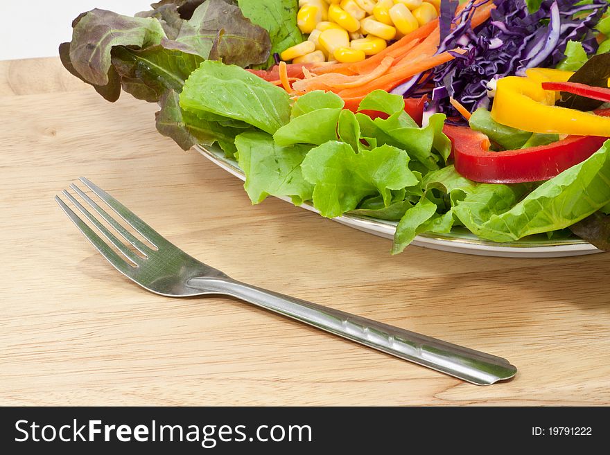 A fork near Vegetable salad in a plate