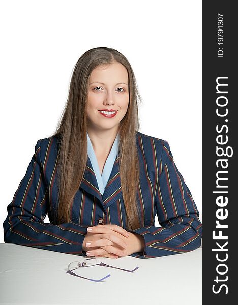 Young girl smiling manager sits behind a white desk, glasses on the table