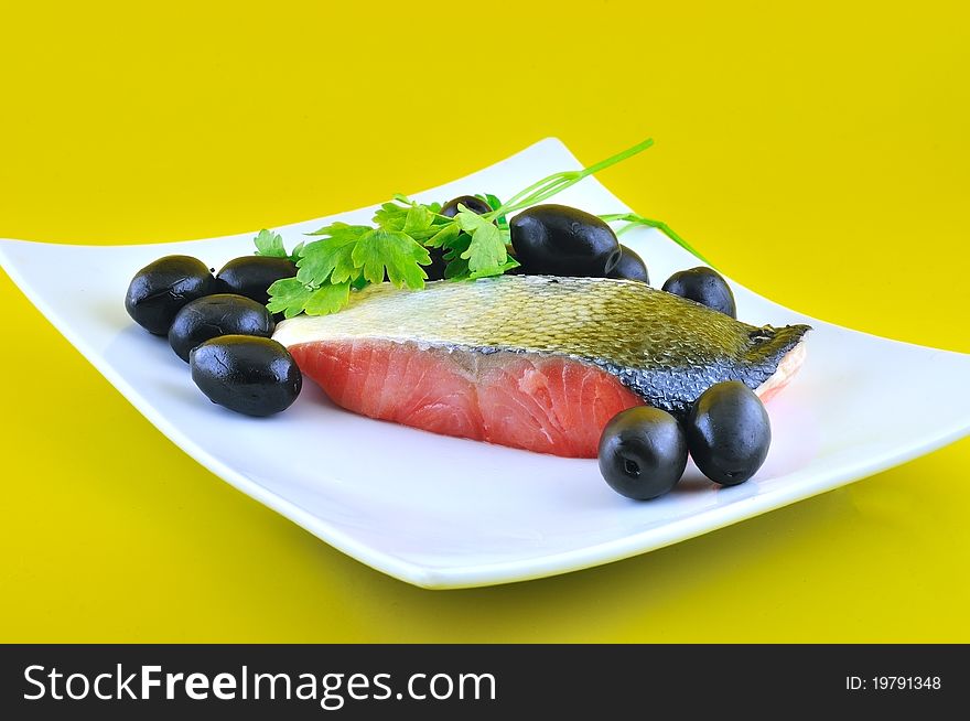 ​​red salt fish and black olives are on a small platter. ​​red salt fish and black olives are on a small platter