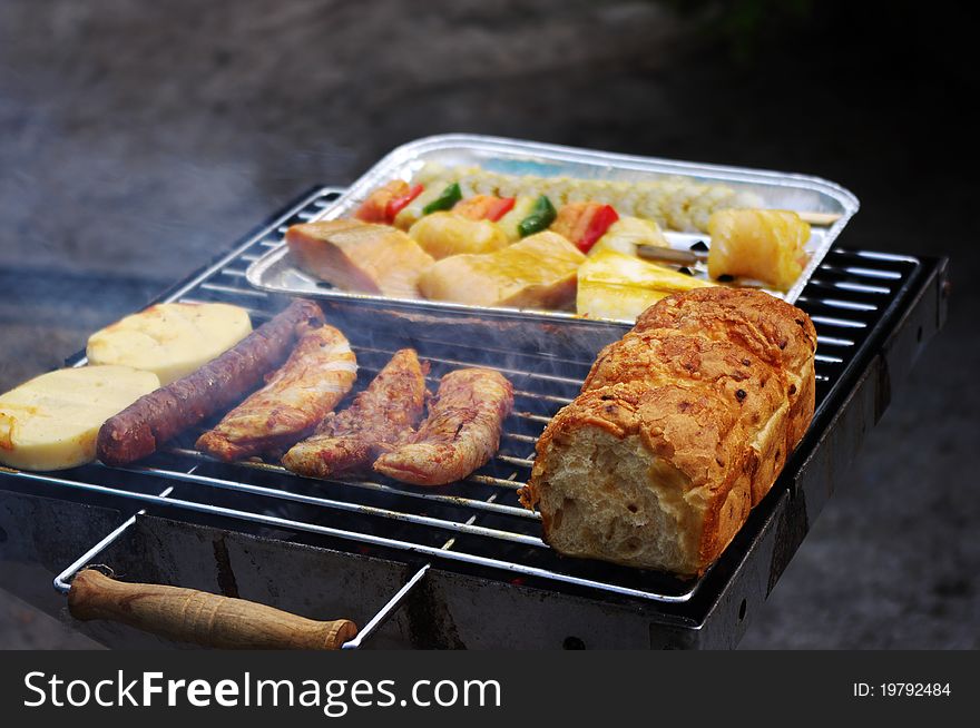 Meat, fish, bread and cheese on the barbecue grill.