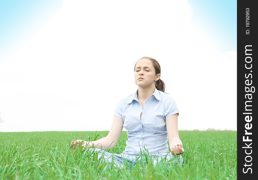 The girl meditating in the field