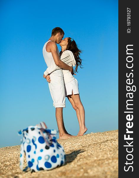 Portrait of young man and woman kissing on a beach. Couple enjoying a summer vacation. Portrait of young man and woman kissing on a beach. Couple enjoying a summer vacation.
