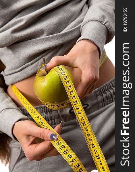 Closeup of  woman holding an apple and measuring  her waist. Closeup of  woman holding an apple and measuring  her waist