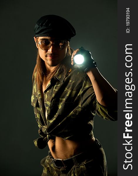 Soldier with flashligh. Studio shot over dark background.