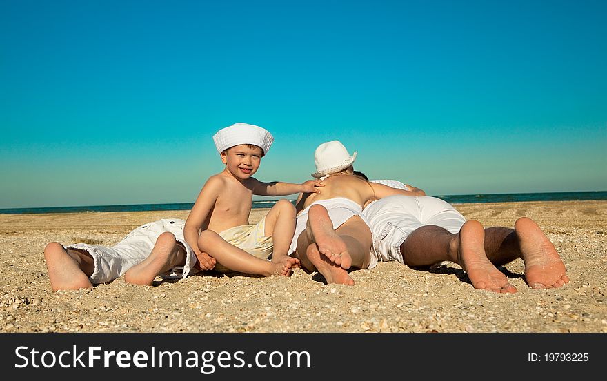 Photo of family lying on sand on background of blue sky