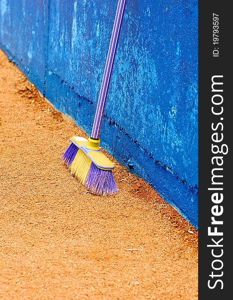 The Plastic besom on sand near concrete wall