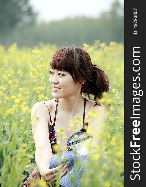 Charming Asian girl relaxing in summer field. Charming Asian girl relaxing in summer field.