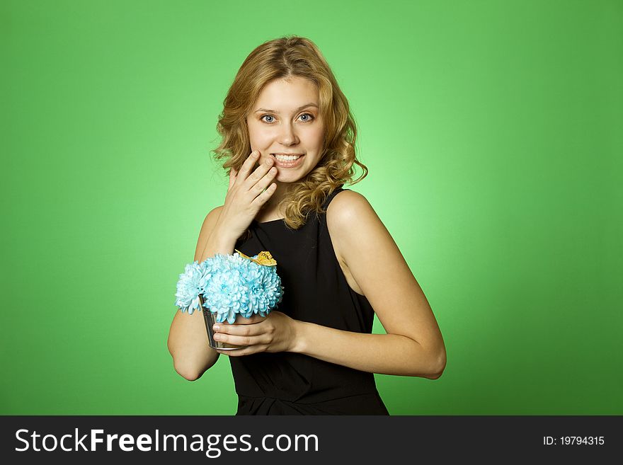 Close-up of an attractive young woman holding a gift bouquet of blue chrysanthemums. Glad surprised. Close-up of an attractive young woman holding a gift bouquet of blue chrysanthemums. Glad surprised
