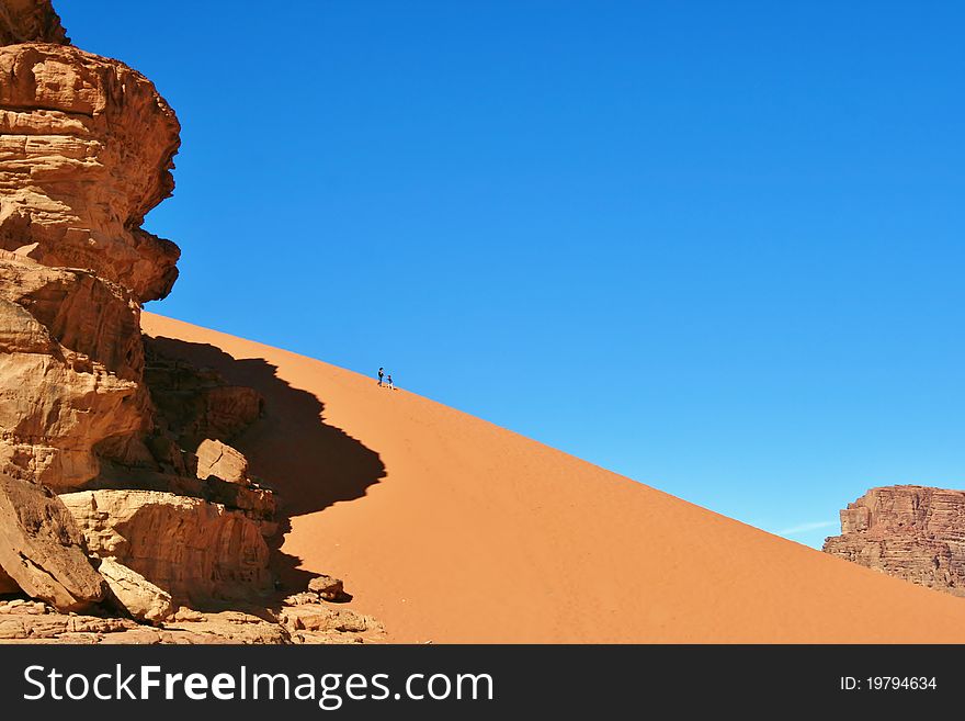 A large sand dune on top which a woman plays with her ​​son. A large sand dune on top which a woman plays with her ​​son