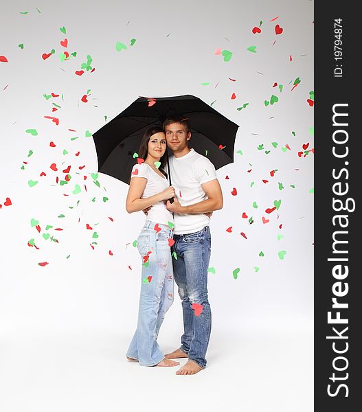 Portrait of a young couple with umbrella and falling hearts