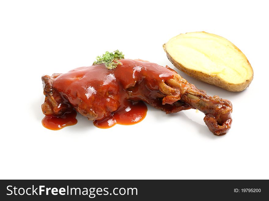 Cooked chicken wings in a sauce and potato isolated in white background