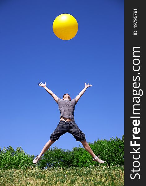 Young man jump with yellow ball