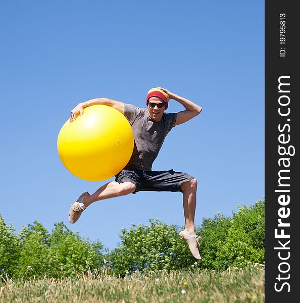 Young man jump in park with yellow ball. Young man jump in park with yellow ball