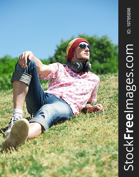 Portrait of young man that laying on grass in park. Portrait of young man that laying on grass in park